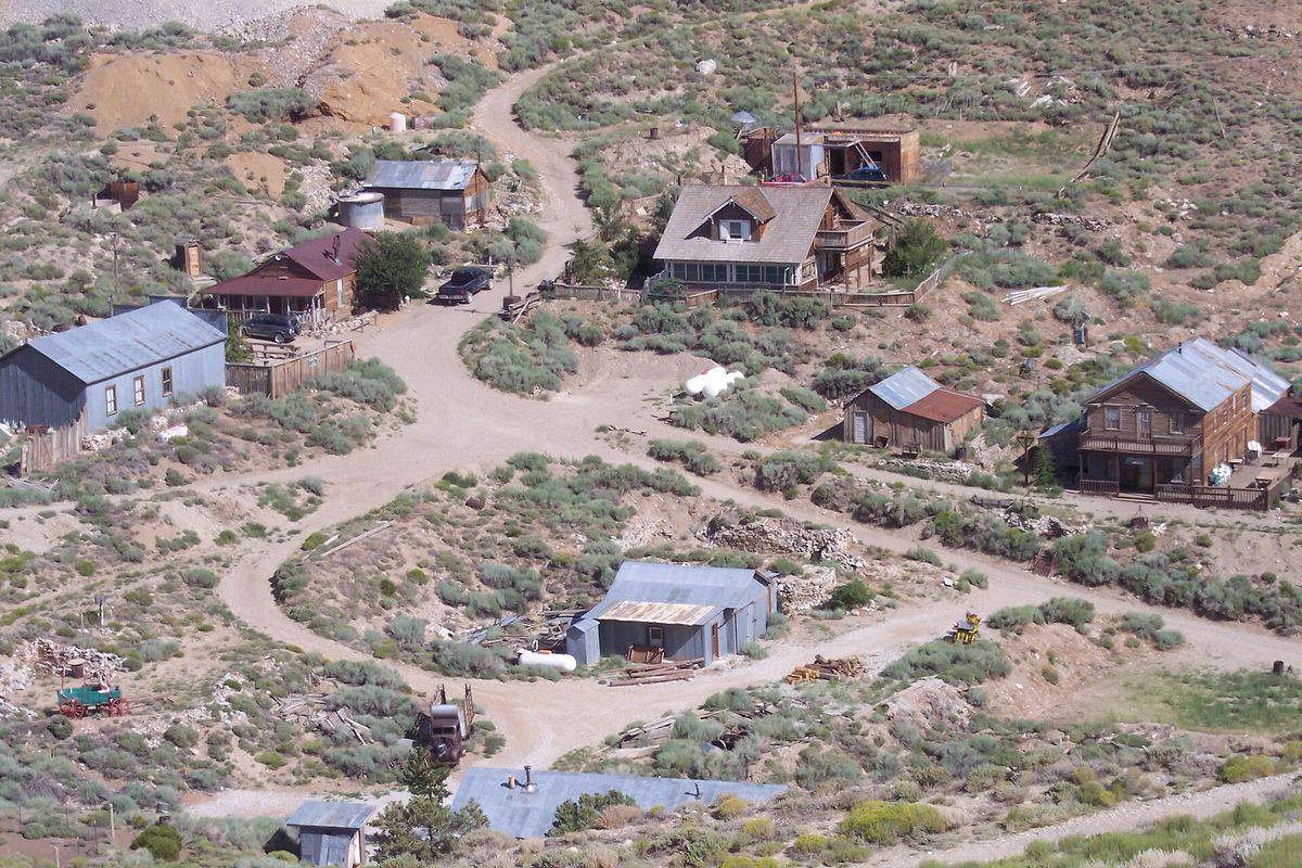 Old wooden buildings and dirt roads of Cerro Gordo seen from the hillside above