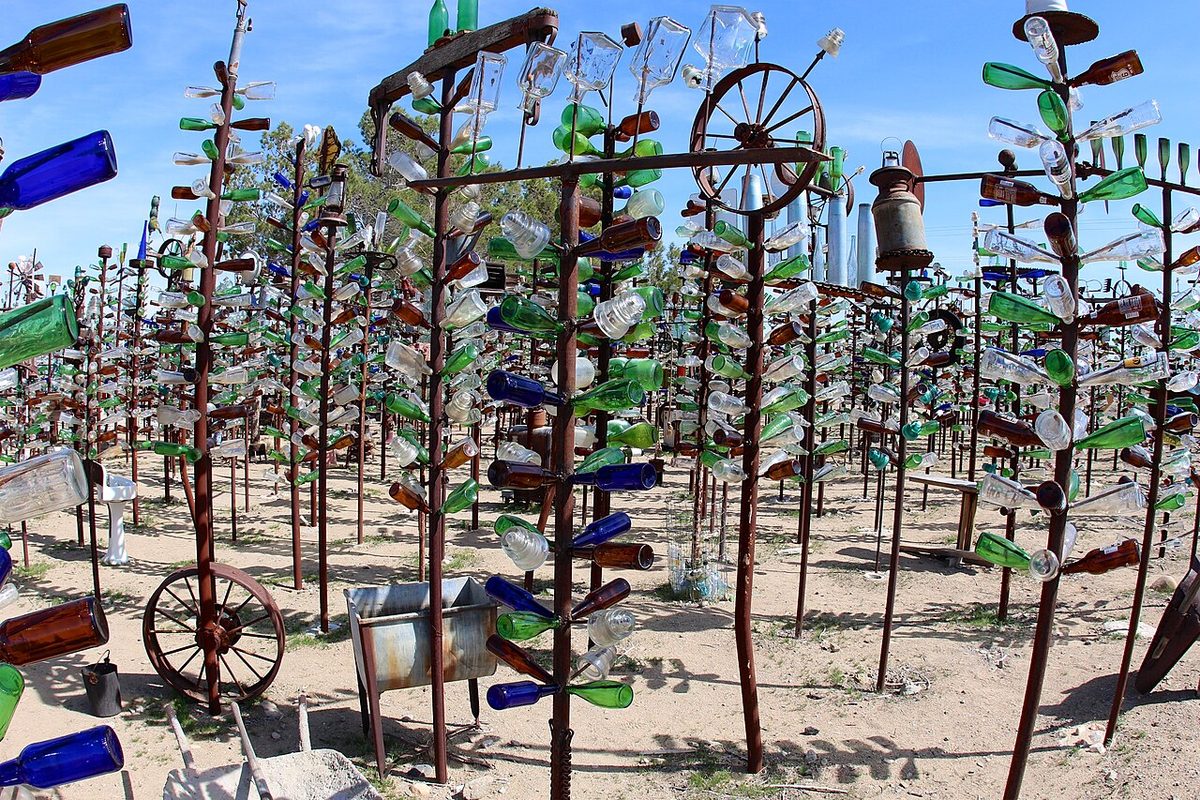 Rows of metal pipe trees hung with colored glass bottles at Elmer's Bottle Tree Ranch