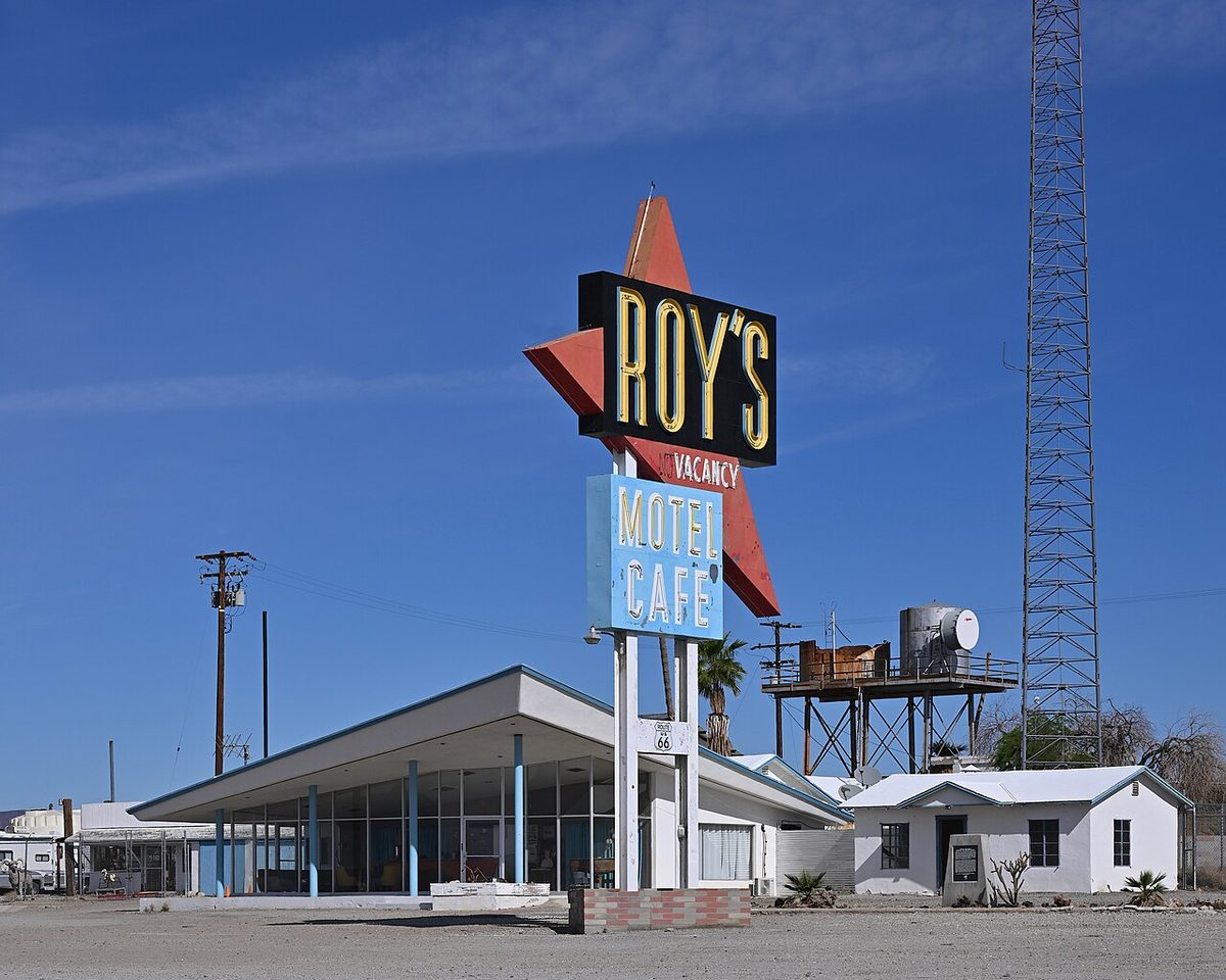 Roy's Motel and Cafe neon sign with a red arrow above the slant-roofed lobby in Amboy, California