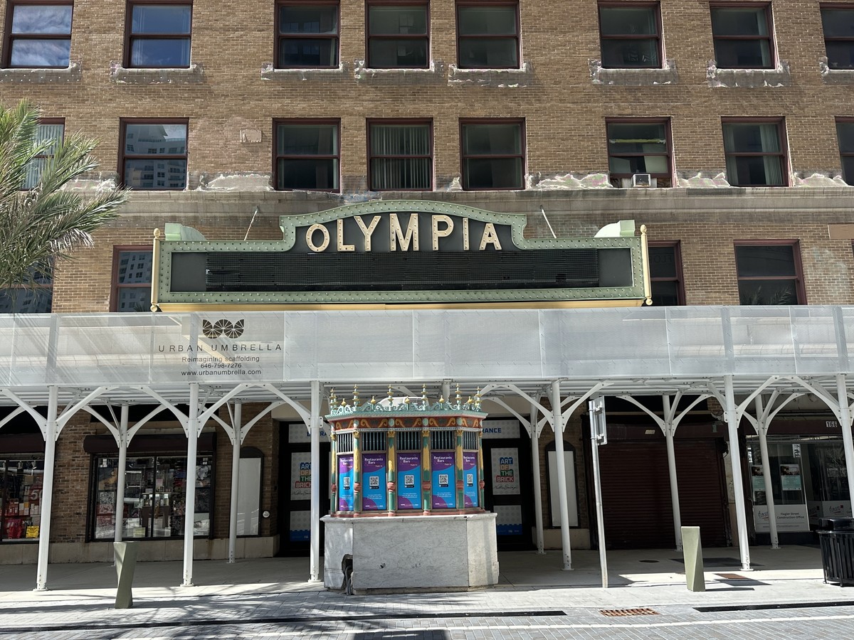 Olympia Theater in Miami, the brick front, the marquee reading OLYMPIA, the ticket booth, and the doors behind the booth