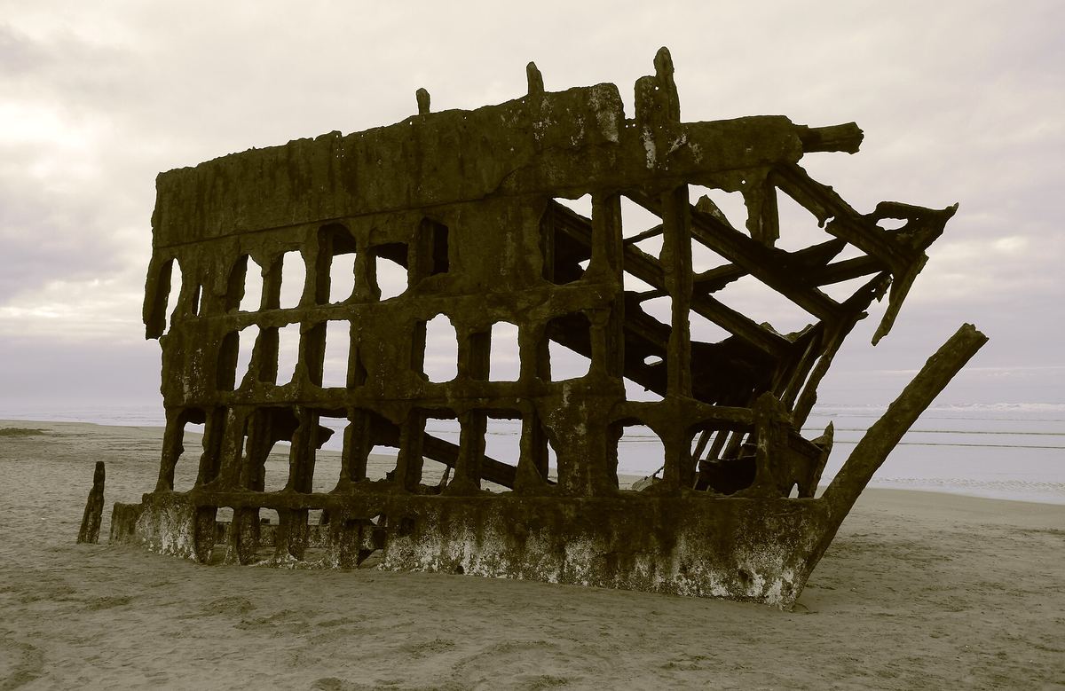 Rusted steel bow and ribs of the Peter Iredale shipwreck on the sand at Fort Stevens State Park