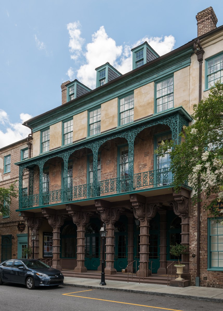 Dock Street Theatre in Charleston, the iron balcony, the teal doors, and the columns along the sidewalk